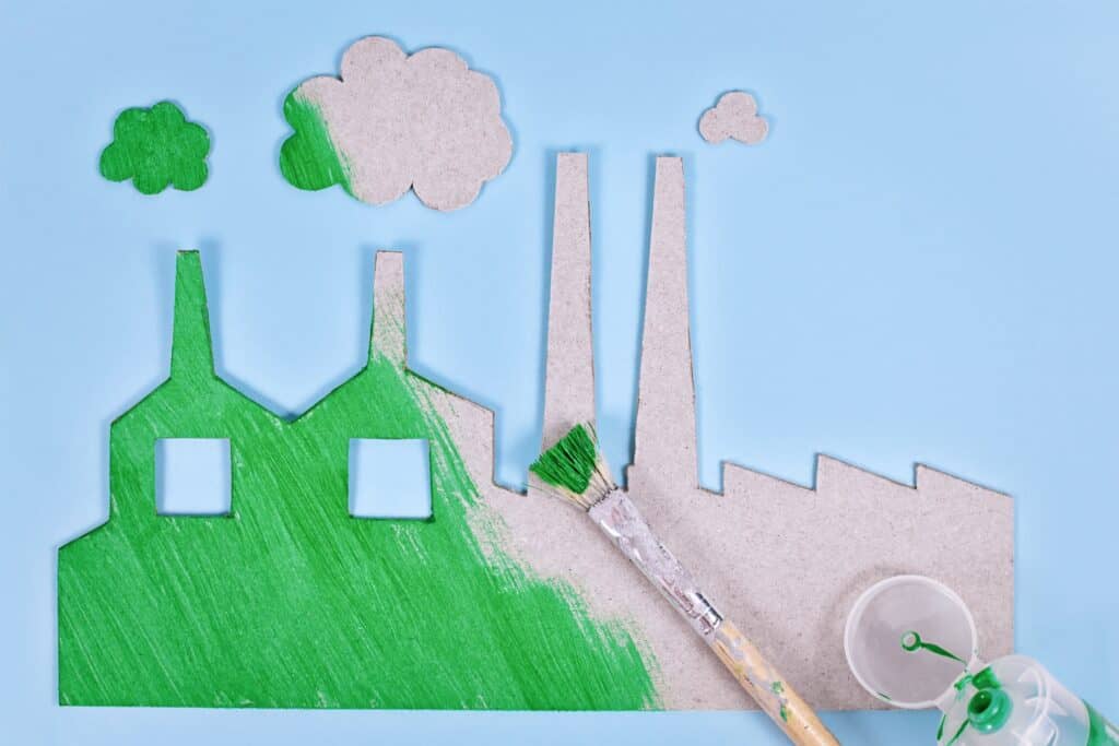 Greenwashing concept with cardboard factory being painted green