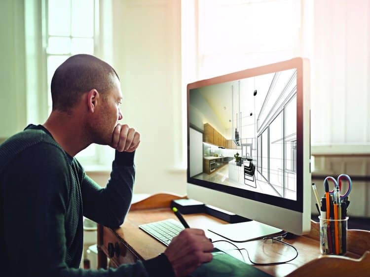 A man uses an iMac to produce digital designs