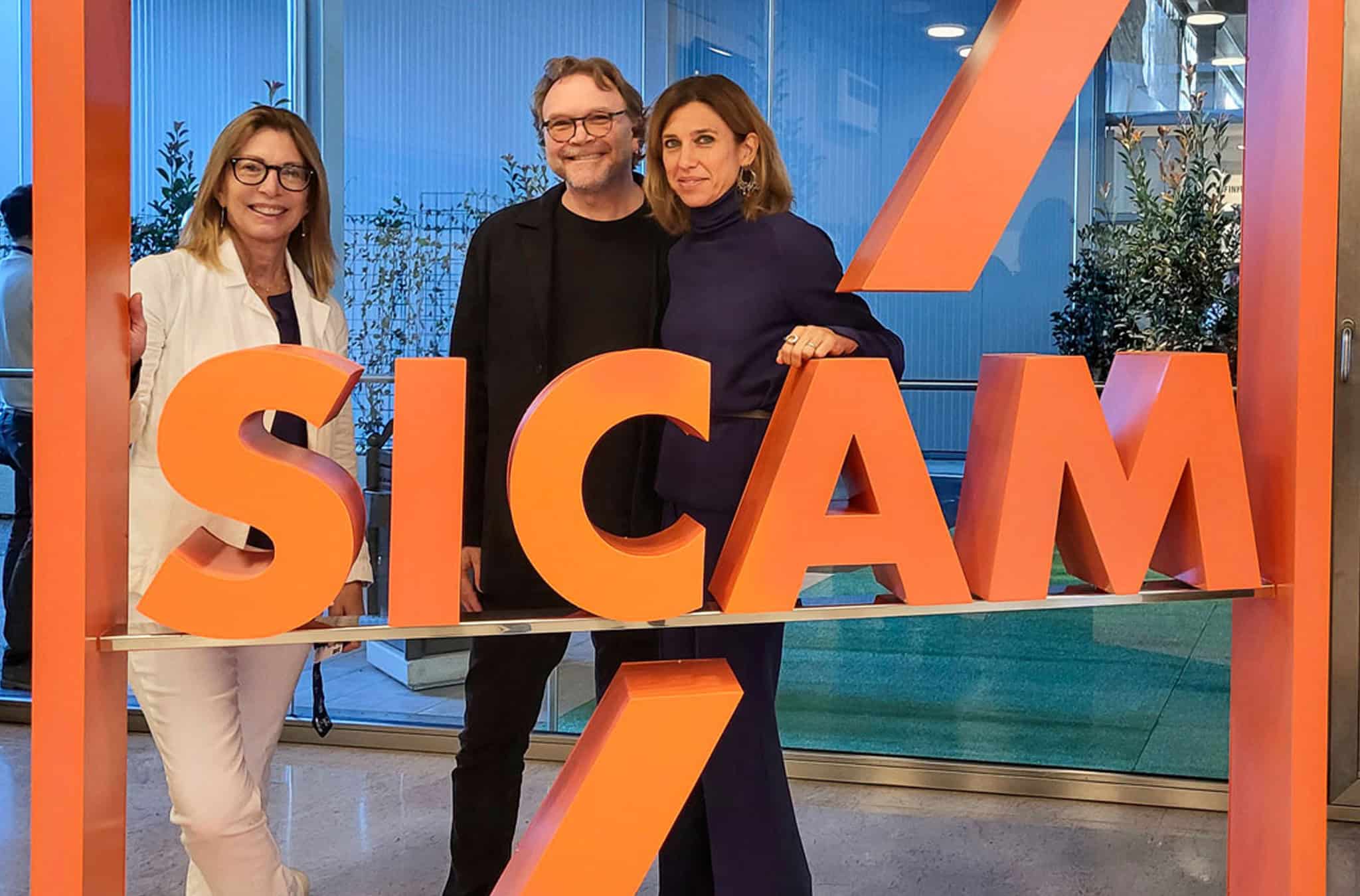 Friends pose at the SICAM expo sign