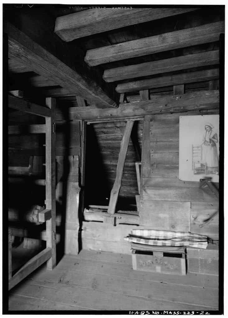 Interior of the 17th-century Fairbanks House showing hand-hewn ceiling beams, joists, and a diagonal timber brace